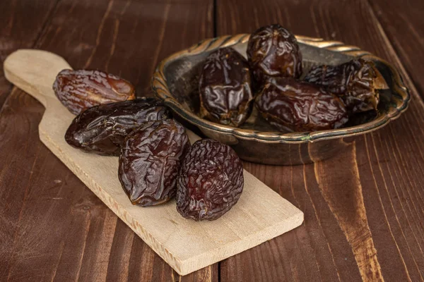 Dried date fruit on brown wood