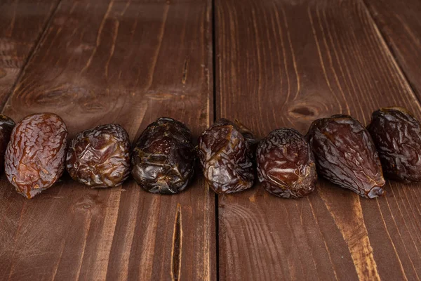 Gedroogde dadelvruchten op bruin hout — Stockfoto