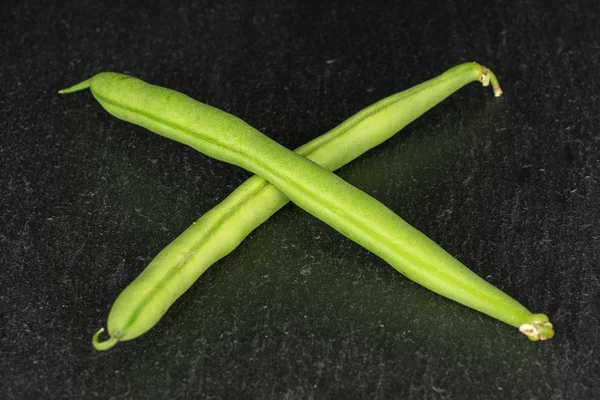 Fresh snap bean on grey stone