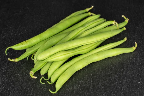 Fresh snap bean on grey stone