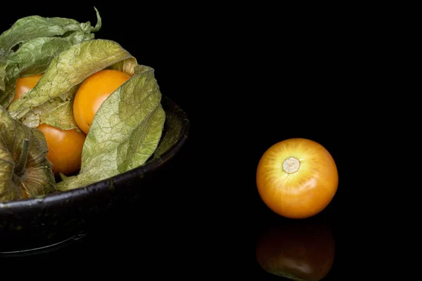 Fresh orange physalis isolated on black glass — Stock Photo, Image