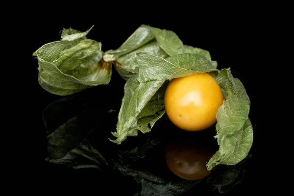 Fresh orange physalis isolated on black glass — Stock Photo, Image