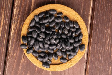 Kahverengi ağaçta kurumuş siyah fasulye.