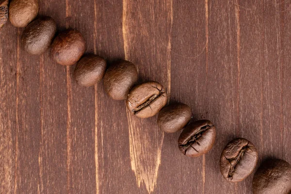 Grão de café fresco em madeira marrom — Fotografia de Stock