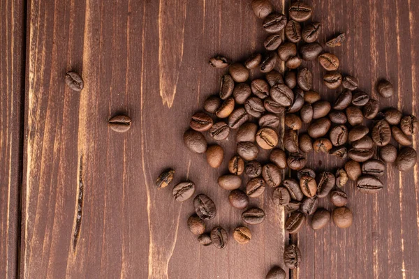 Grão de café fresco em madeira marrom — Fotografia de Stock