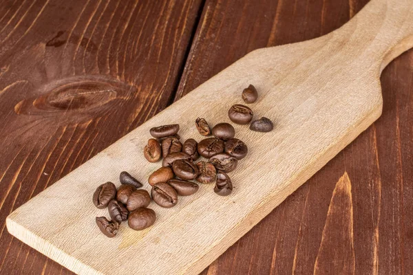 Frische Kaffeebohnen auf braunem Holz — Stockfoto