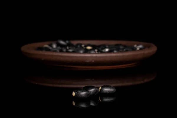Gedroogde zwarte boon geïsoleerd op zwart glas — Stockfoto