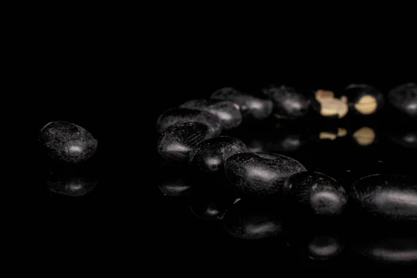 Dried black bean isolated on black glass — Stock Photo, Image