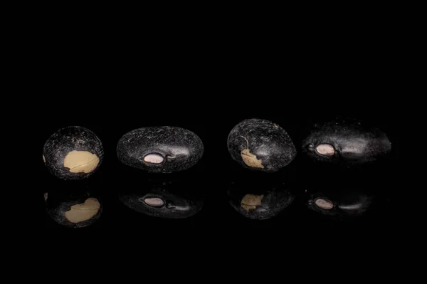 Dried black bean isolated on black glass — Stock Photo, Image