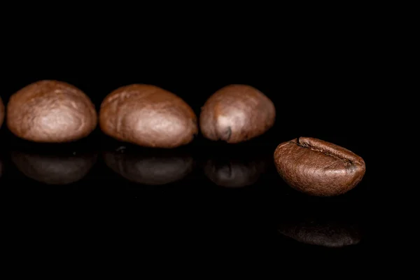 Свежий кофе бобы изолированы на черном стекле — стоковое фото