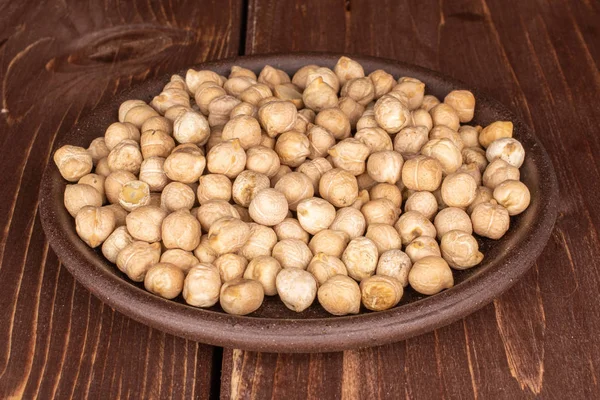 Fresh tan chickpea on brown wood — 图库照片