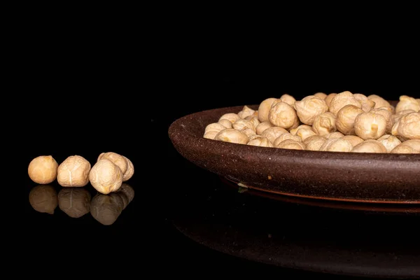 Fresh tan chickpea isolated on black glass — Stock Photo, Image
