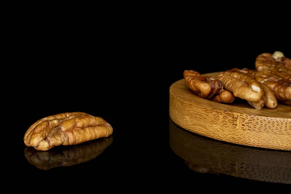 Brown pecan nut isolated on black glass — Stock Photo, Image