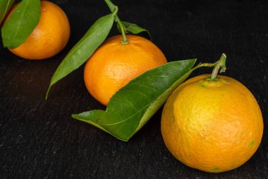 Gri taşın üzerinde taze turuncu mandalina.