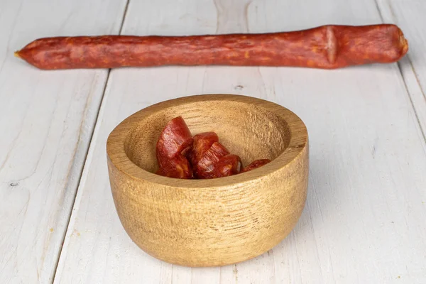 Geräucherte würzige Wurst auf grauem Holz — Stockfoto