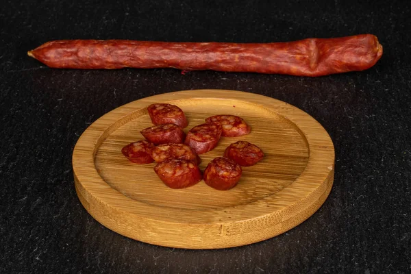 Копченая острая колбаса на сером камне — стоковое фото