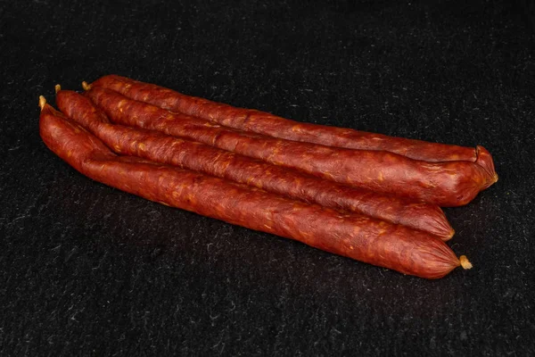 Smoked spicy sausage on grey stone — Stockfoto