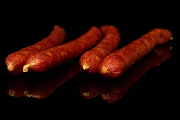 Копченая острая колбаса на черном стекле — стоковое фото