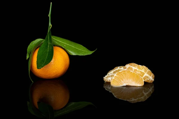 Fresh orange mandarin isolated on black glass — Stock Photo, Image