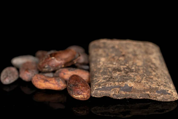 Kahverengi kakao çekirdeği siyah camda izole edilmiş. — Stok fotoğraf