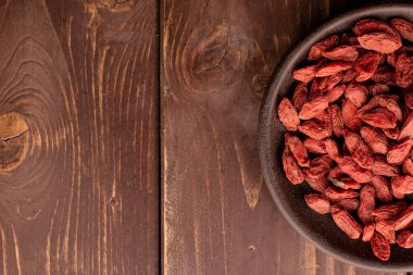 Red dried goji on brown wood