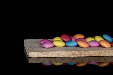 Siyah camda izole edilmiş tatlı renkli şekerler.