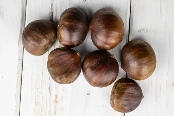 Bruine eetbare kastanje op grijs hout — Stockfoto