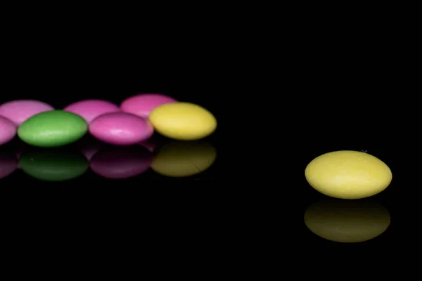 Słodkie kolorowe cukierki izolowane na czarnym szkle — Zdjęcie stockowe