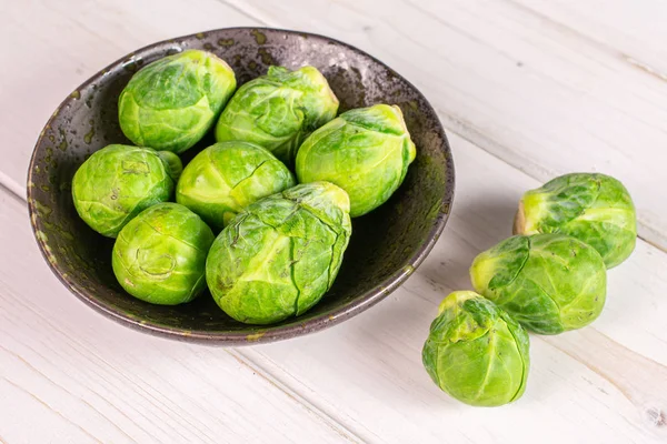 Grüne Rosenkohl sprießen auf grauem Holz — Stockfoto