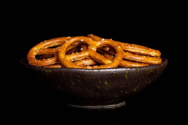 Siyah camda izole edilmiş tuzlu kahverengi simit.