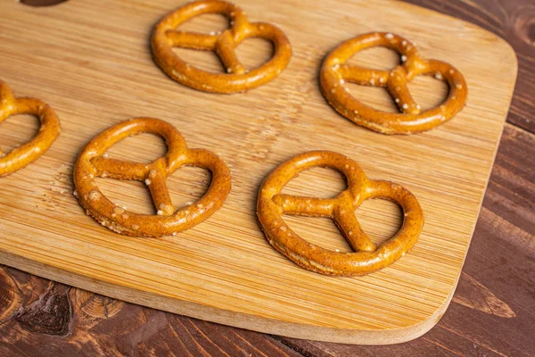 Salty brown pretzel on brown wood — Stock Photo, Image