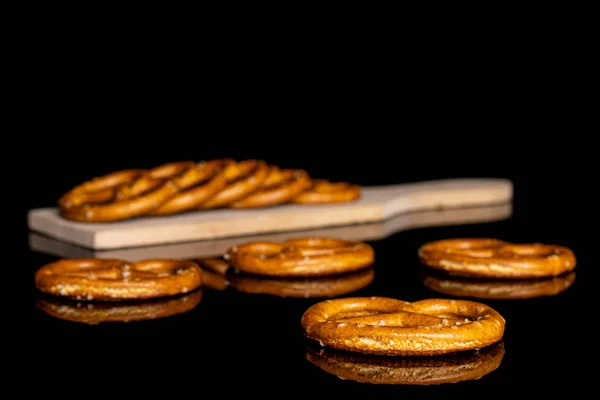 Salty brown pretzel isolated on black glass — Stock Photo, Image