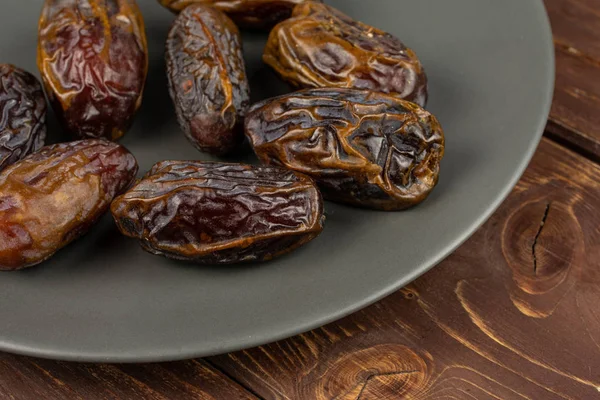 Dry brown date fruit on brown wood — Stok fotoğraf