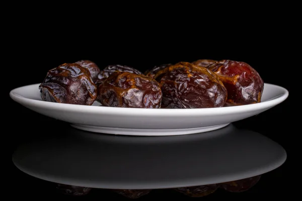 Dry brown date fruit isolated on black glass — Stock Photo, Image