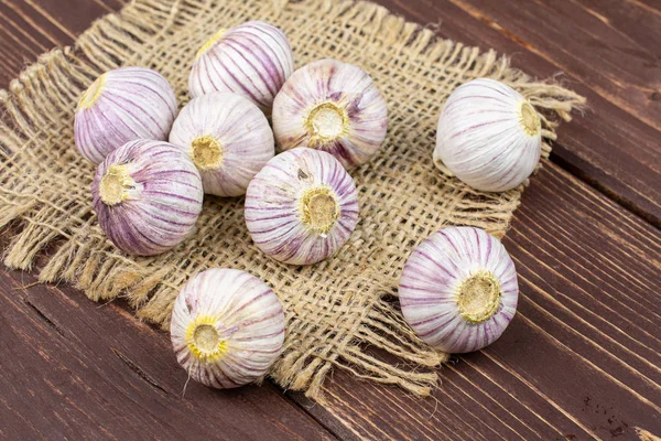 Single clove garlic on brown wood — 图库照片