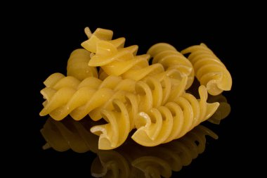 Bir sürü sarı makarna yığını siyah camda izole edilmiş.