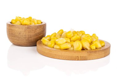 Bambu kabında beyaz arka planda izole edilmiş bir sürü konserve sarı mısır.