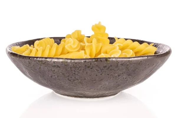 在白色背景上隔离的釉面碗中 放了很多全黄的意大利面 — 图库照片