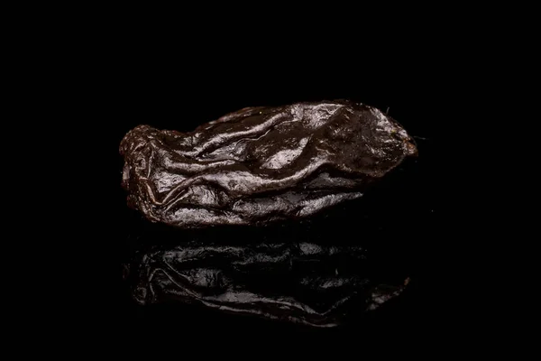 Een Hele Gedroogde Donkere Rozijn Geïsoleerd Zwart Glas — Stockfoto