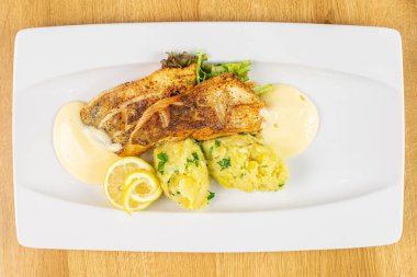 Beyaz dikdörtgen seramik tabakta ezilmiş patatesli güzel zander.