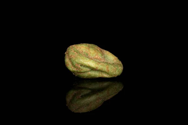 One whole wasabi green peanut isolated on black glass