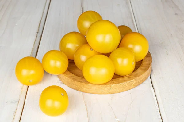 Lot Whole Fresh Yellow Tomato Bamboo Coaster White Wood — Stock Photo, Image