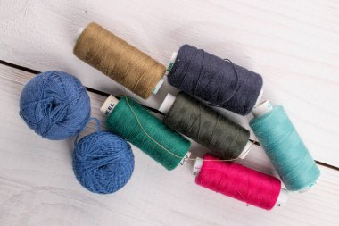 Beyaz ahşap üzerinde bir sürü renkli iplik makarası