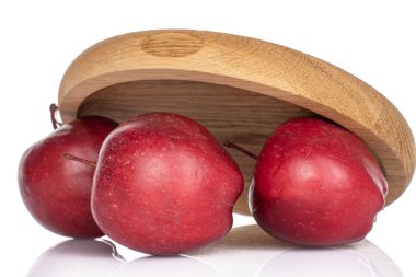 Beyaz tenli, ahşap altlığın altında üç büyük kırmızı elma grubu.