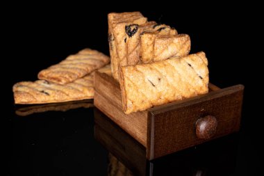 Siyah camda izole edilmiş kuru üzümlü kare şeklinde kurabiyeler.