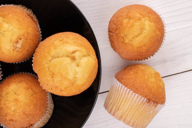 Beyaz ahşap tabakta beş küçük kekten oluşan bir grup