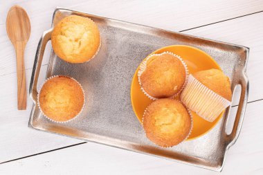 Beyaz ahşap tepside beş küçük kek grubu.