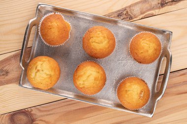 Tahtadaki tepside altı küçük kek grubu.