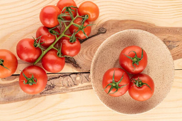 Lot of whole fresh red cherry tomato three on plate on wood