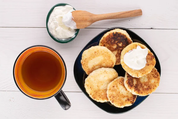 六组全脂芝士煎饼加一杯茶和白木酸奶油 — 图库照片